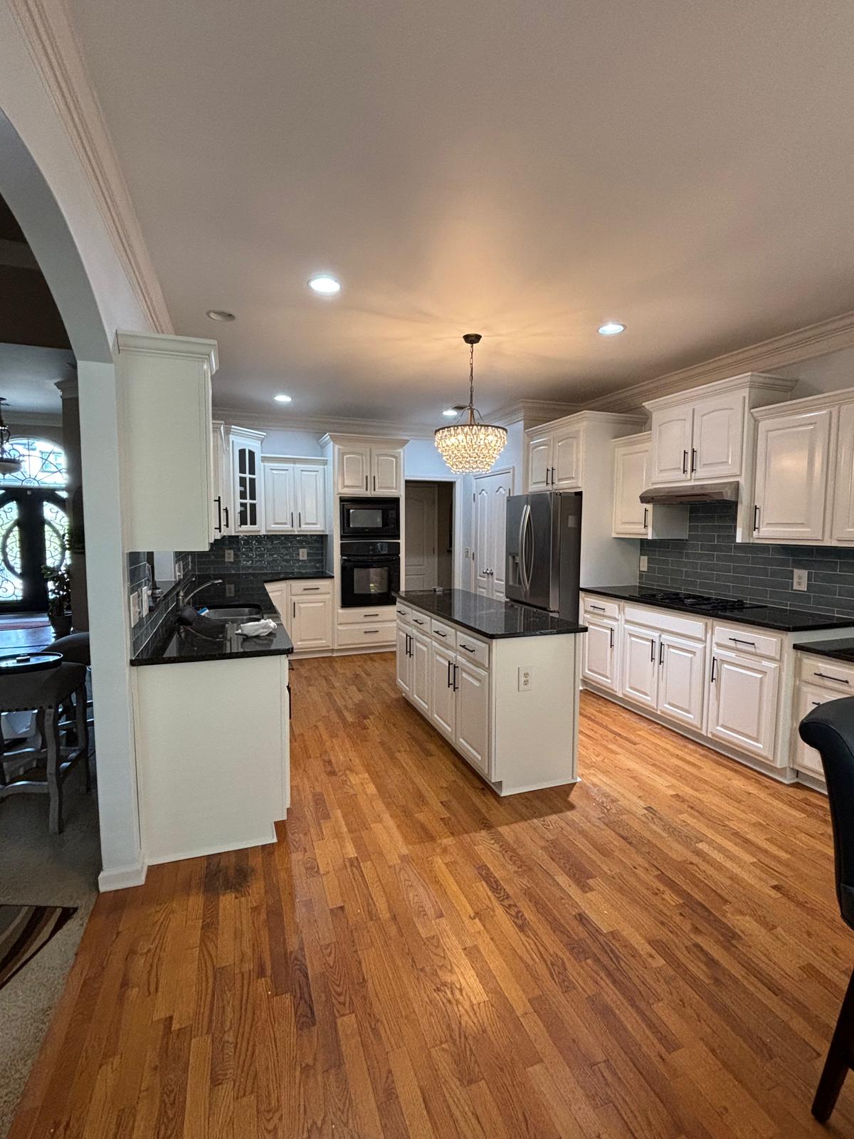 Remodeled kitchen with white cabinets, granite counters, and hardwood floors in Snellville, GA